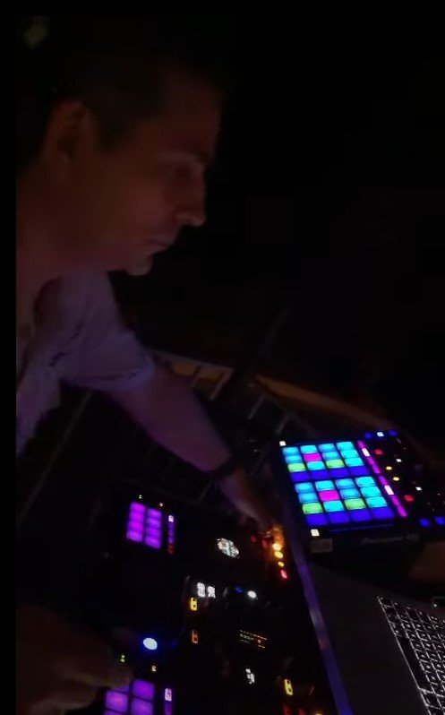 DJ T-973 en set, éclairé par les pads de sa console
